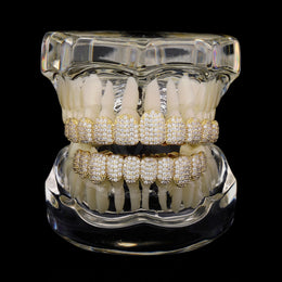 Gold micro-pavé CZ upper and lower grillz on a dental display model