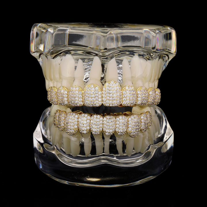 Gold micro-pavé CZ upper and lower grillz on a dental display model