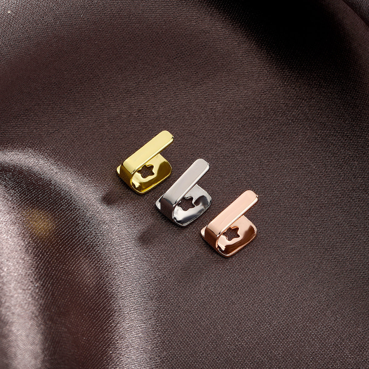 Gold, Silver and Rose Gold bar tooth caps on brown fabric