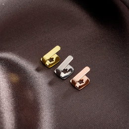 Gold, Silver and Rose Gold bar tooth caps on brown fabric