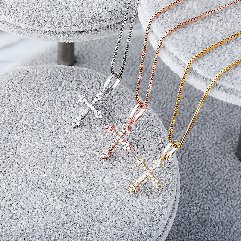 Three iced ornate cross pendant finishes on grey velvet