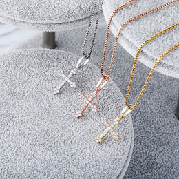 Three iced ornate cross pendant finishes on grey velvet