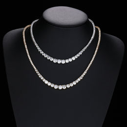 Silver- and gold-tone graduated tennis necklaces draped on a black bust