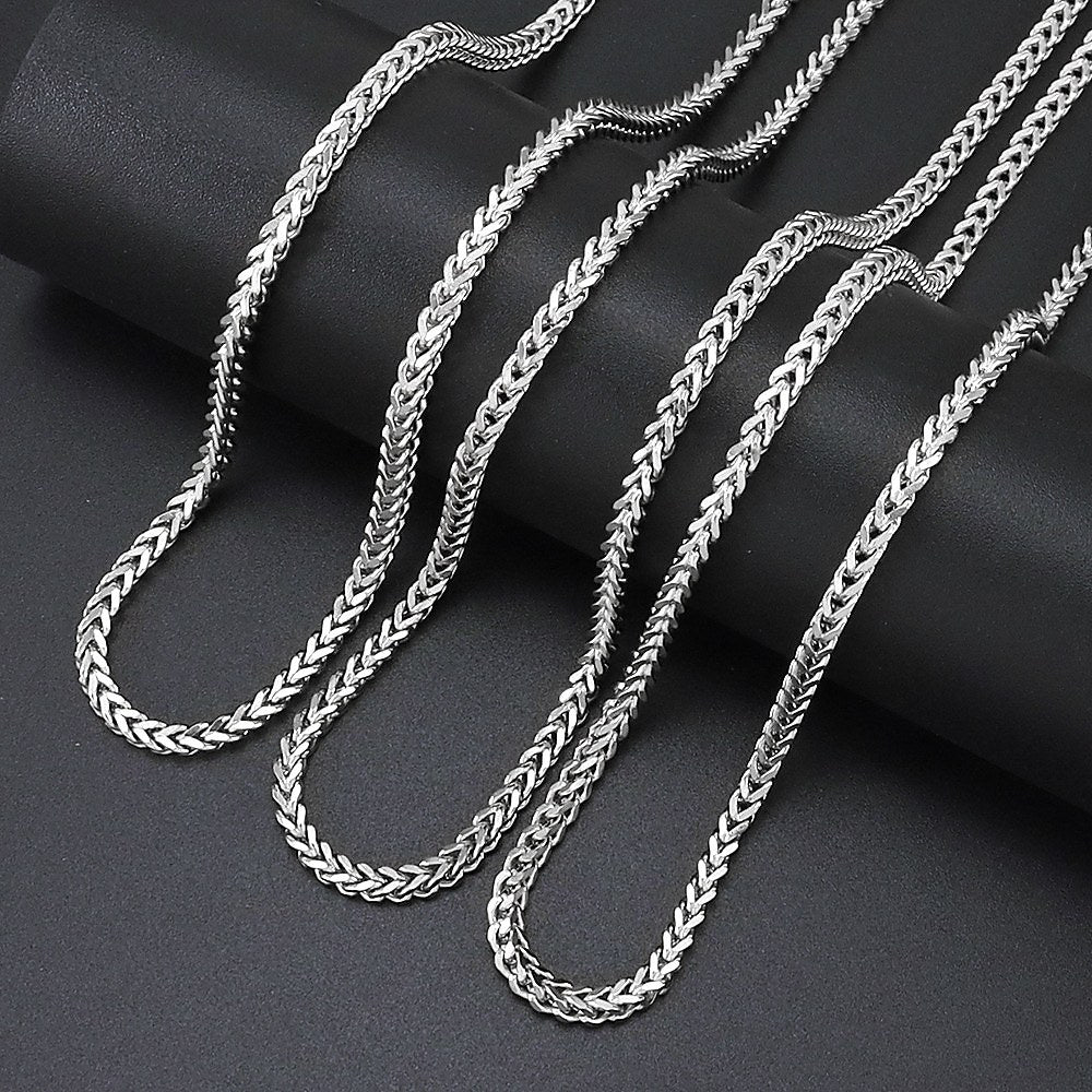 Silver 3mm Franco Chain links arranged on black fabric