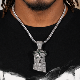 Silver-tone crowned portrait pendant worn by a brown-skinned model