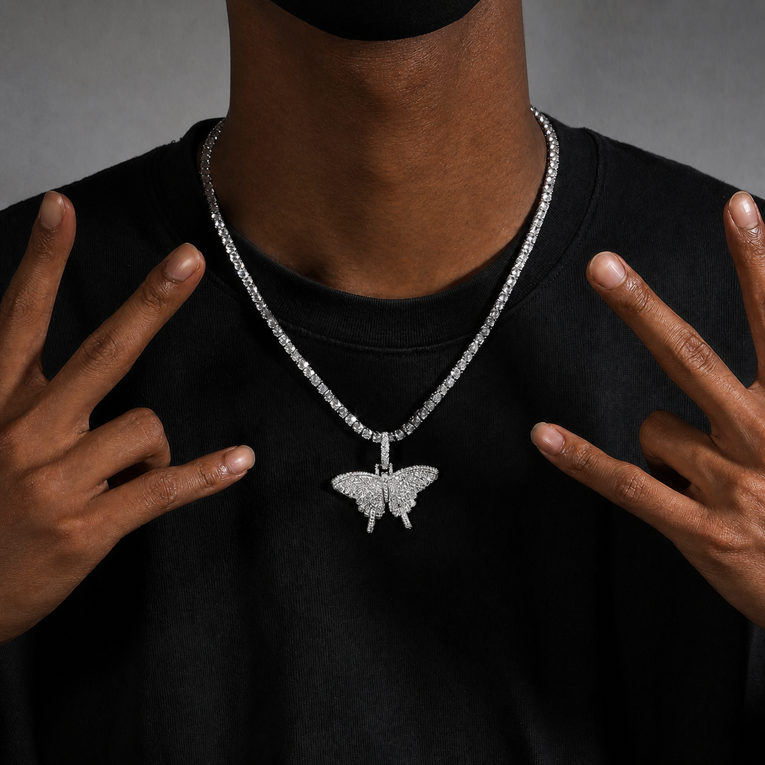 Mini solid iced butterfly pendant worn by a deep-brown model