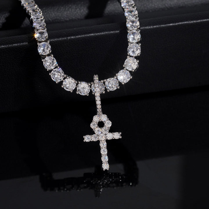 Silver-tone clear-stone ankh pendant on a tennis chain against black
