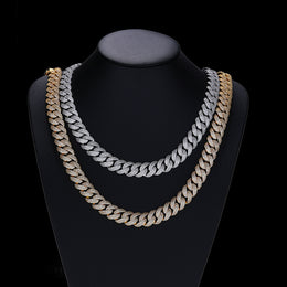 Silver- and gold-tone pavé Cuban necklaces draped on a black display bust