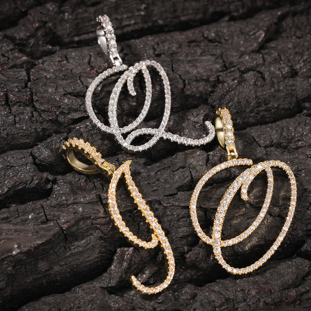 Gold-tone and silver-tone cubic zirconia script letter pendants on bark