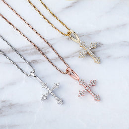 Close view of silver gold and rose gold iced cross pendants