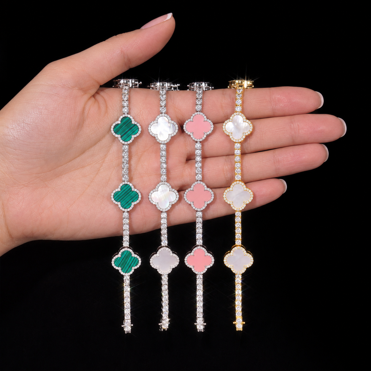 Green, Silver / White, Pink and Gold / White clover bracelets displayed across an adult hand