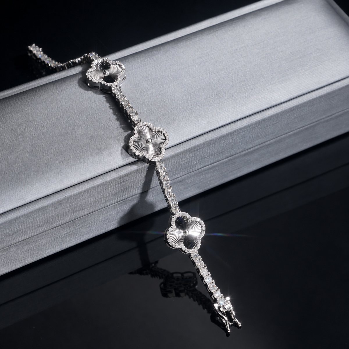 Silver-tone radial engraved clover details draped over a gray display bar