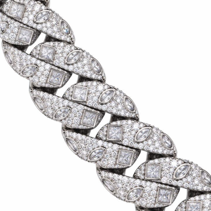 Close-up of silver-tone Cuban links with square and marquise accents on white