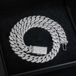 Silver-tone Cuban necklace coiled on a black tray with its box clasp open