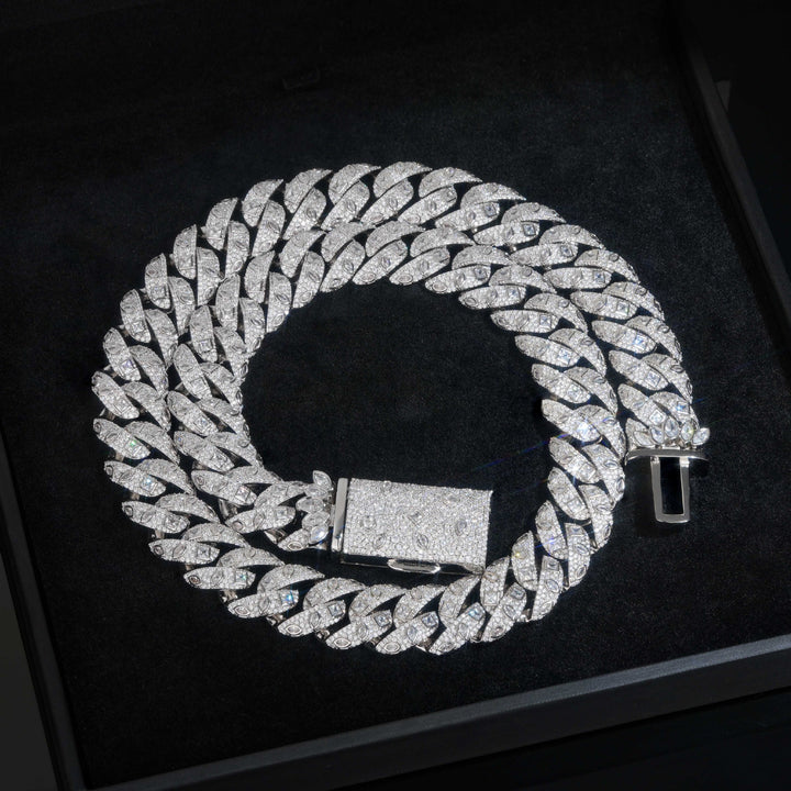 Silver-tone Cuban necklace coiled on a black tray with its box clasp open