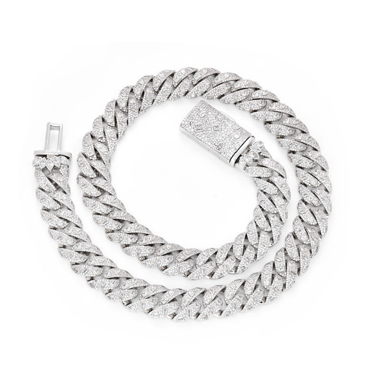 Silver-tone Cuban necklace coiled on white with its box clasp open