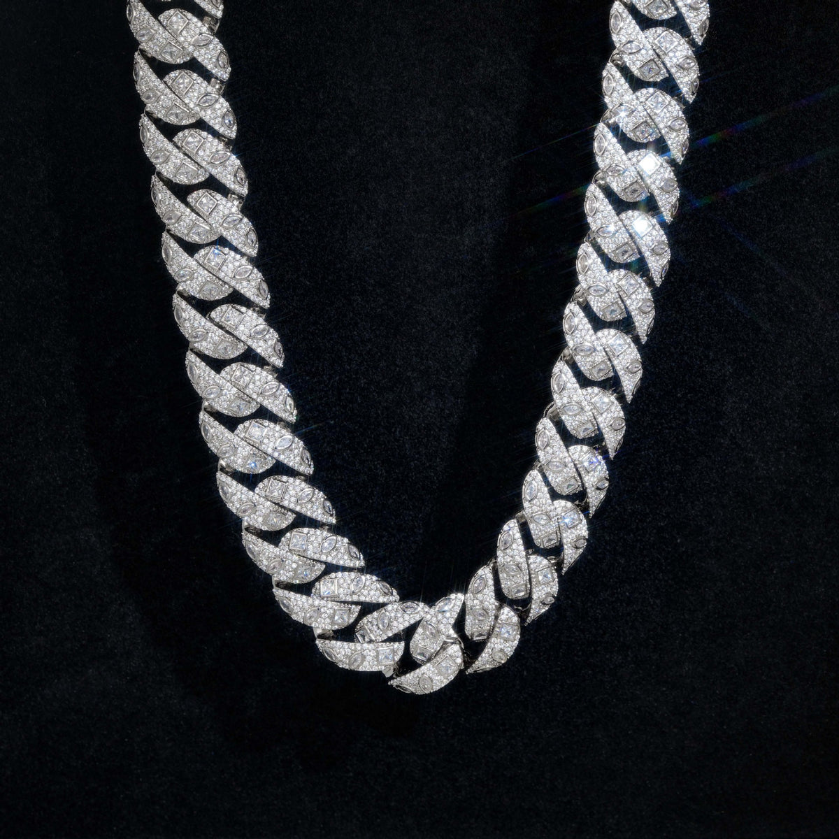 Close-up of silver-tone Cuban links showing square and marquise accents