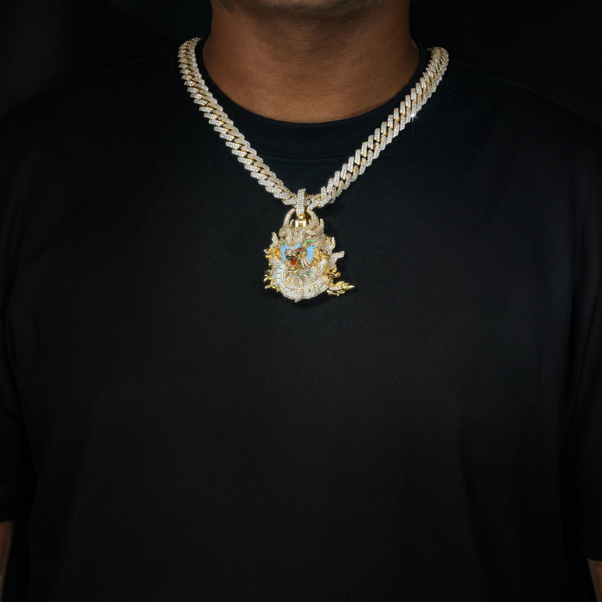 Gold iced dragon pendant worn over a black shirt
