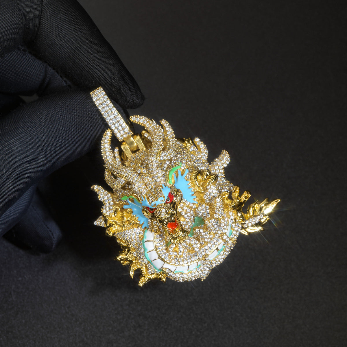 Gold iced dragon pendant held in a black glove