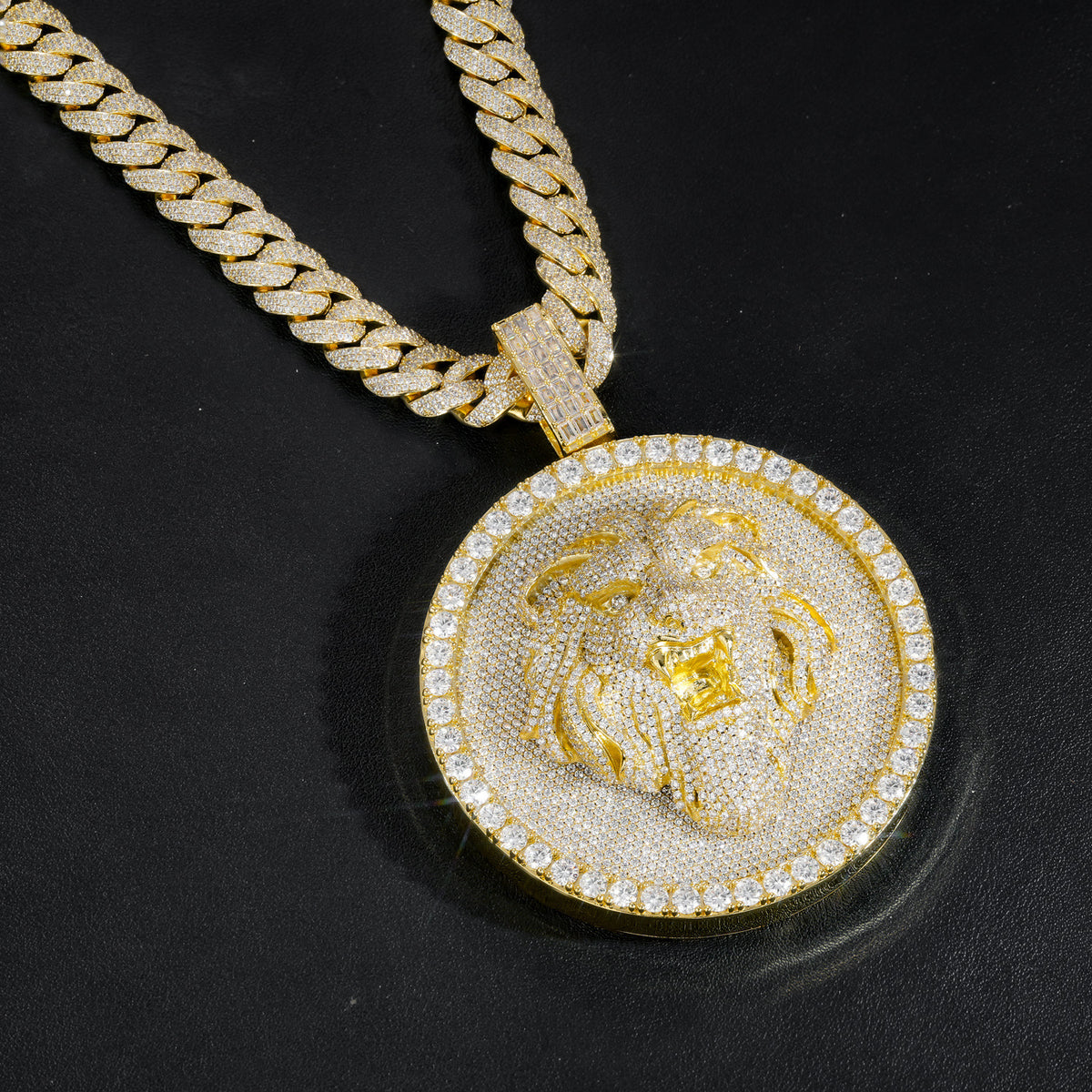 Gold-tone lion medallion pendant hanging against black leather