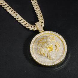 Gold-tone lion medallion pendant hanging against black leather