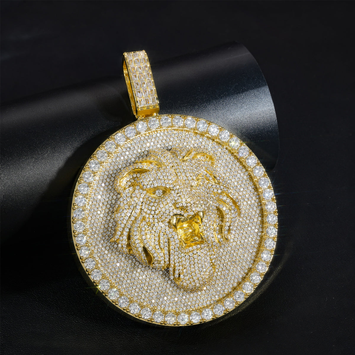 Gold-tone lion medallion pendant resting on a rolled black display