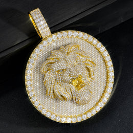 Angled gold-tone lion medallion pendant close-up on a black box