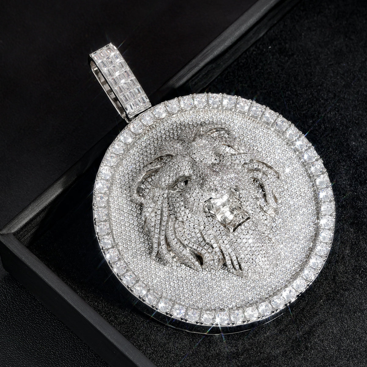 Angled silver-tone lion medallion pendant close-up on a black box