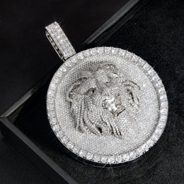 Angled silver-tone lion medallion pendant close-up on a black box