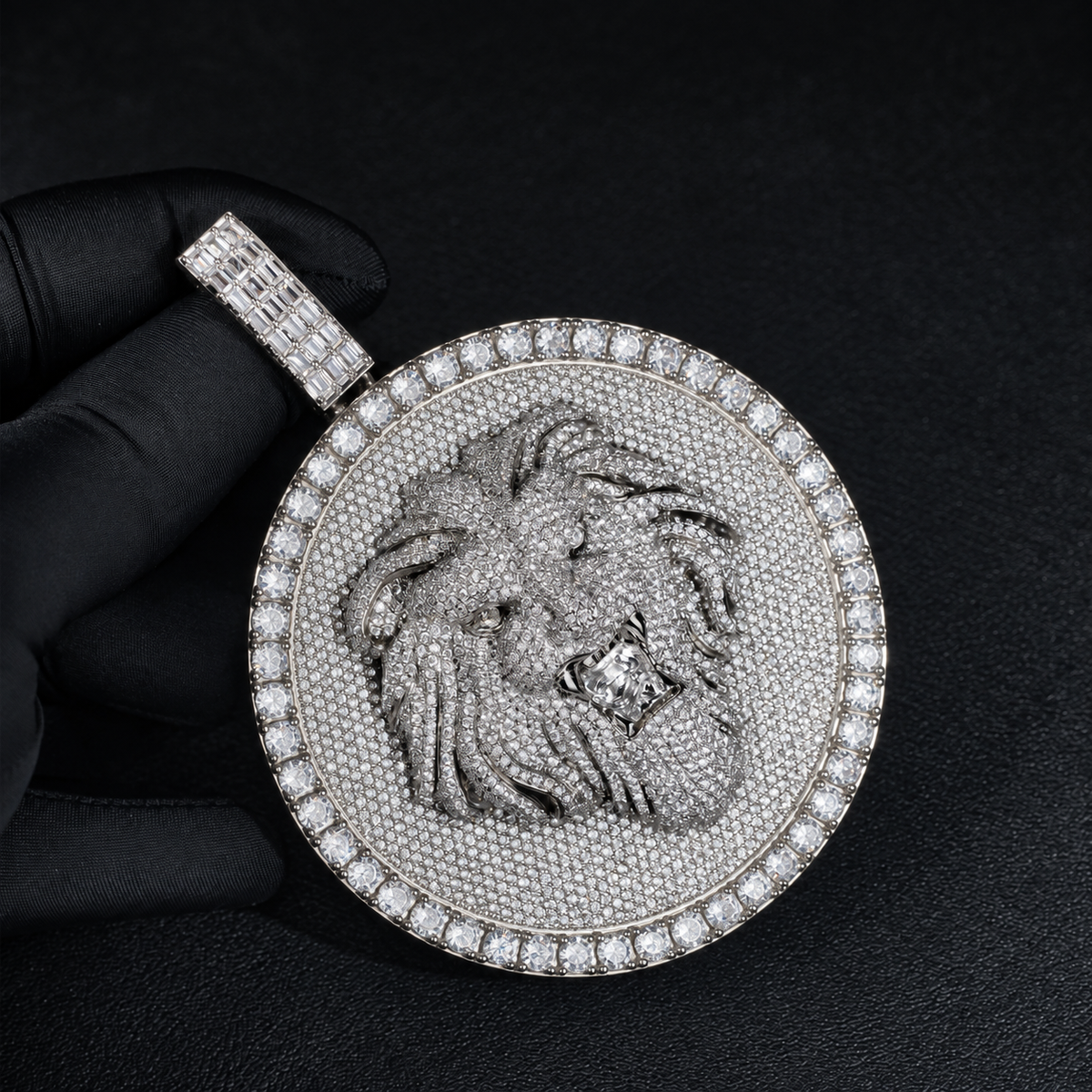 Silver-tone lion medallion pendant held by black-gloved fingers