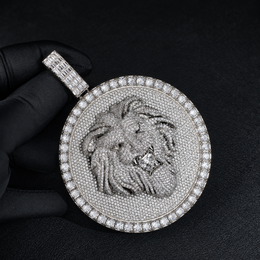 Silver-tone lion medallion pendant held by black-gloved fingers