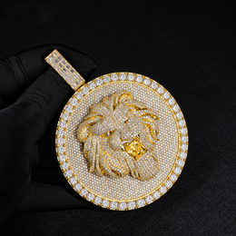 Gold-tone lion medallion pendant held by black-gloved fingers