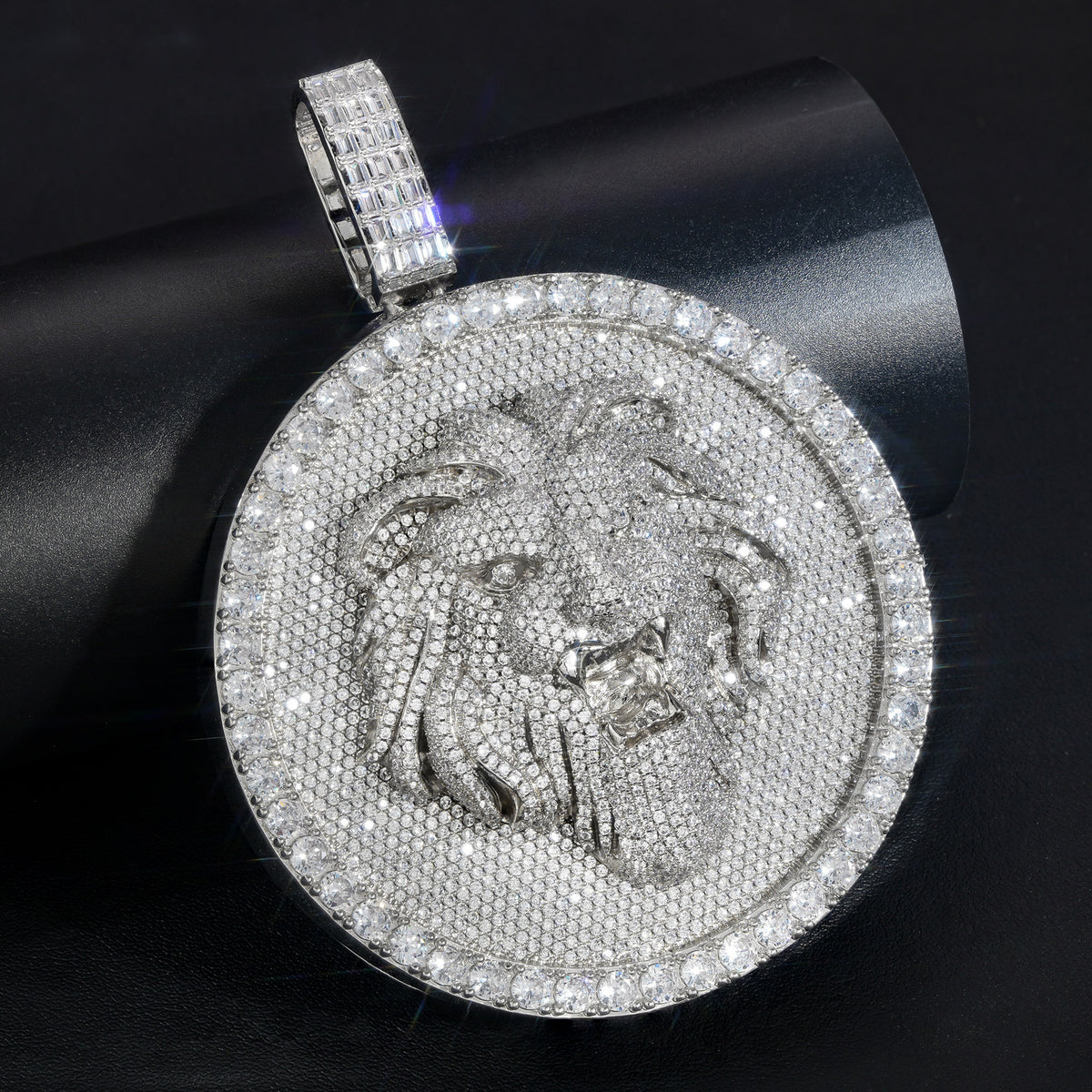 Silver-tone lion medallion pendant close-up on a rolled black display