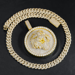 Gold-tone lion medallion pendant laid flat on black leather
