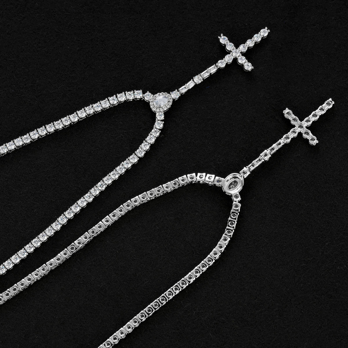 Front and reverse of the slender silver-tone cross drop tennis necklace showing open settings