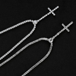 Front and reverse of the slender silver-tone cross drop tennis necklace showing open settings