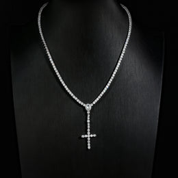 Slender silver-tone cross drop tennis necklace on a black display bust