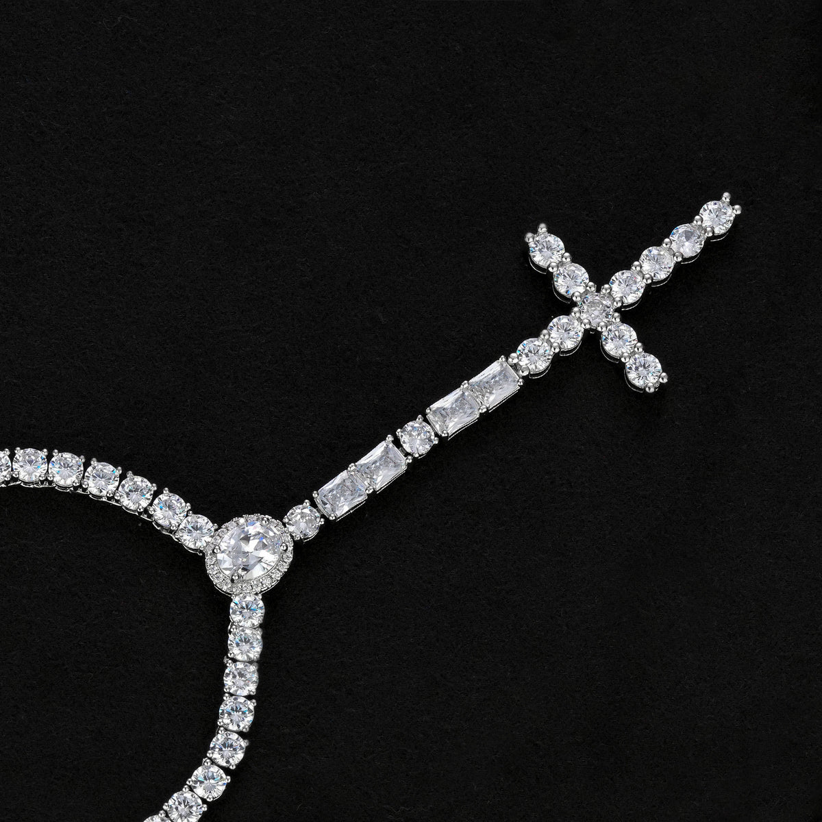 Silver-tone cross drop necklace showing the oval halo, rectangular accents and stone-set cross on black