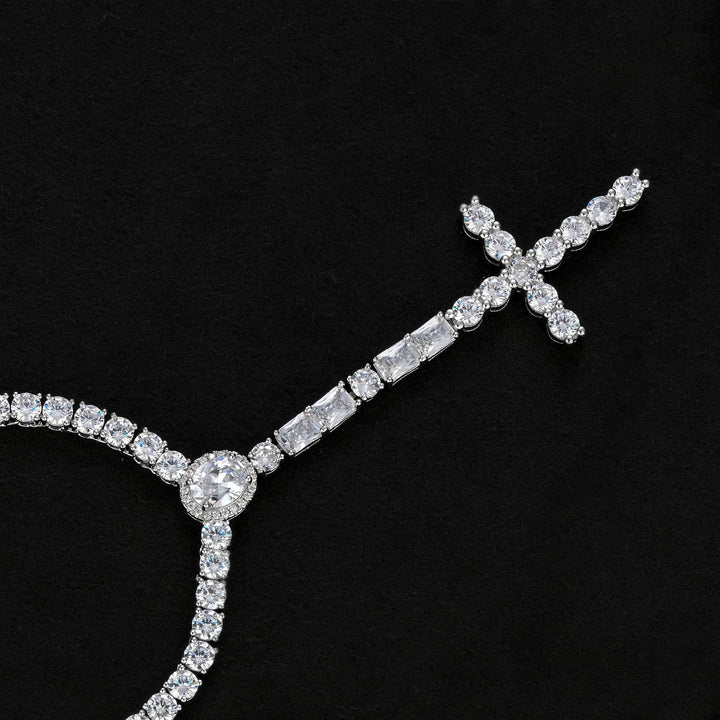 Silver-tone cross drop necklace showing the oval halo, rectangular accents and stone-set cross on black