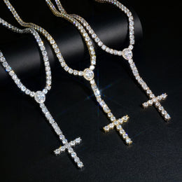 Silver, Gold and Rose Gold cross drop tennis necklaces draped over a black display roll