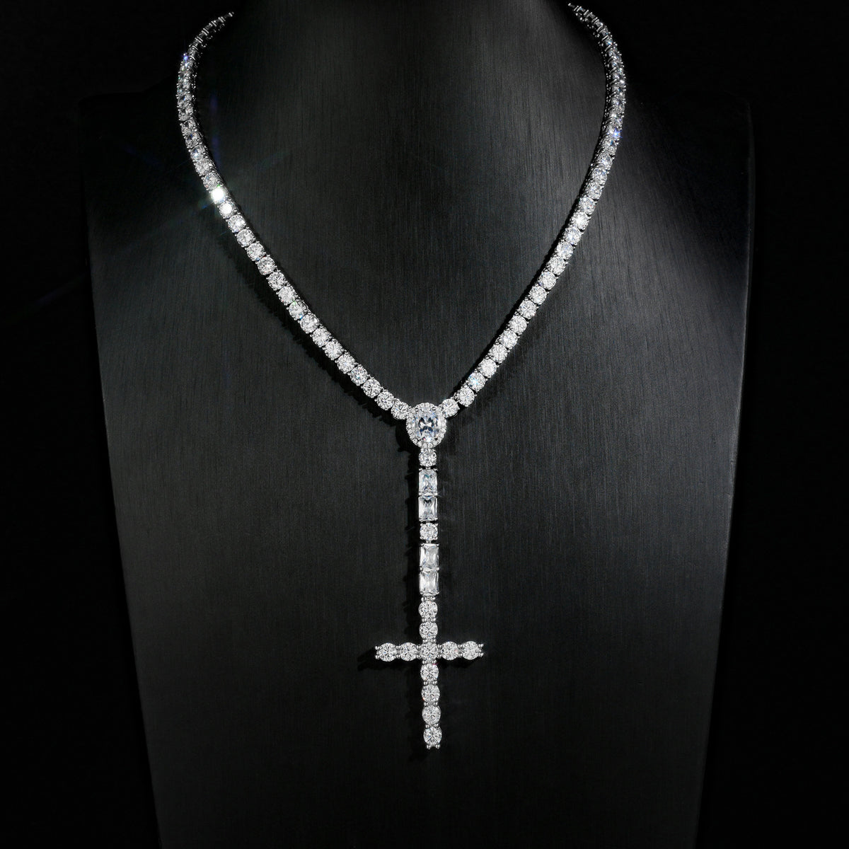 Silver-tone wider cross drop tennis necklace displayed on a black bust