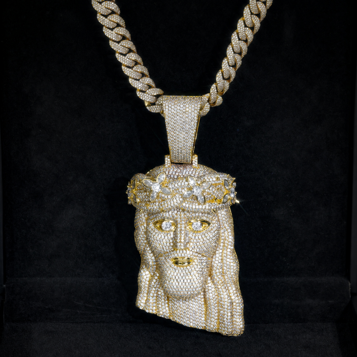 Gold-tone crowned Jesus pendant displayed against black fabric