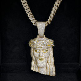 Gold-tone crowned Jesus pendant displayed against black fabric