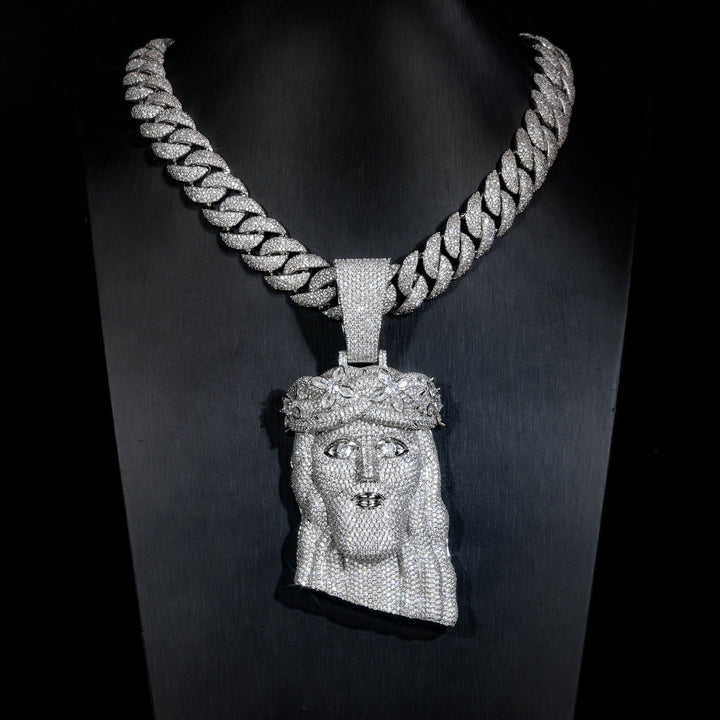 Silver-tone crowned Jesus pendant on a black display bust