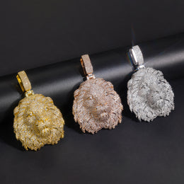 Gold-tone, rose-gold-tone and silver-tone lion head pendants angled on a black box