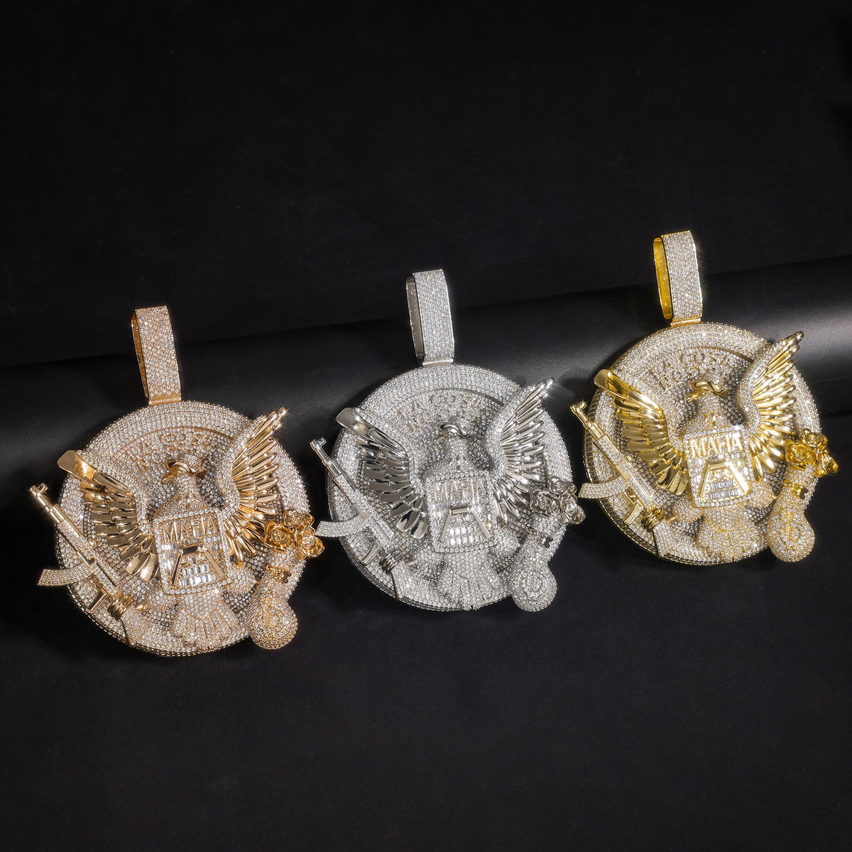 Silver, gold and rose gold-tone eagle medallion pendants on black