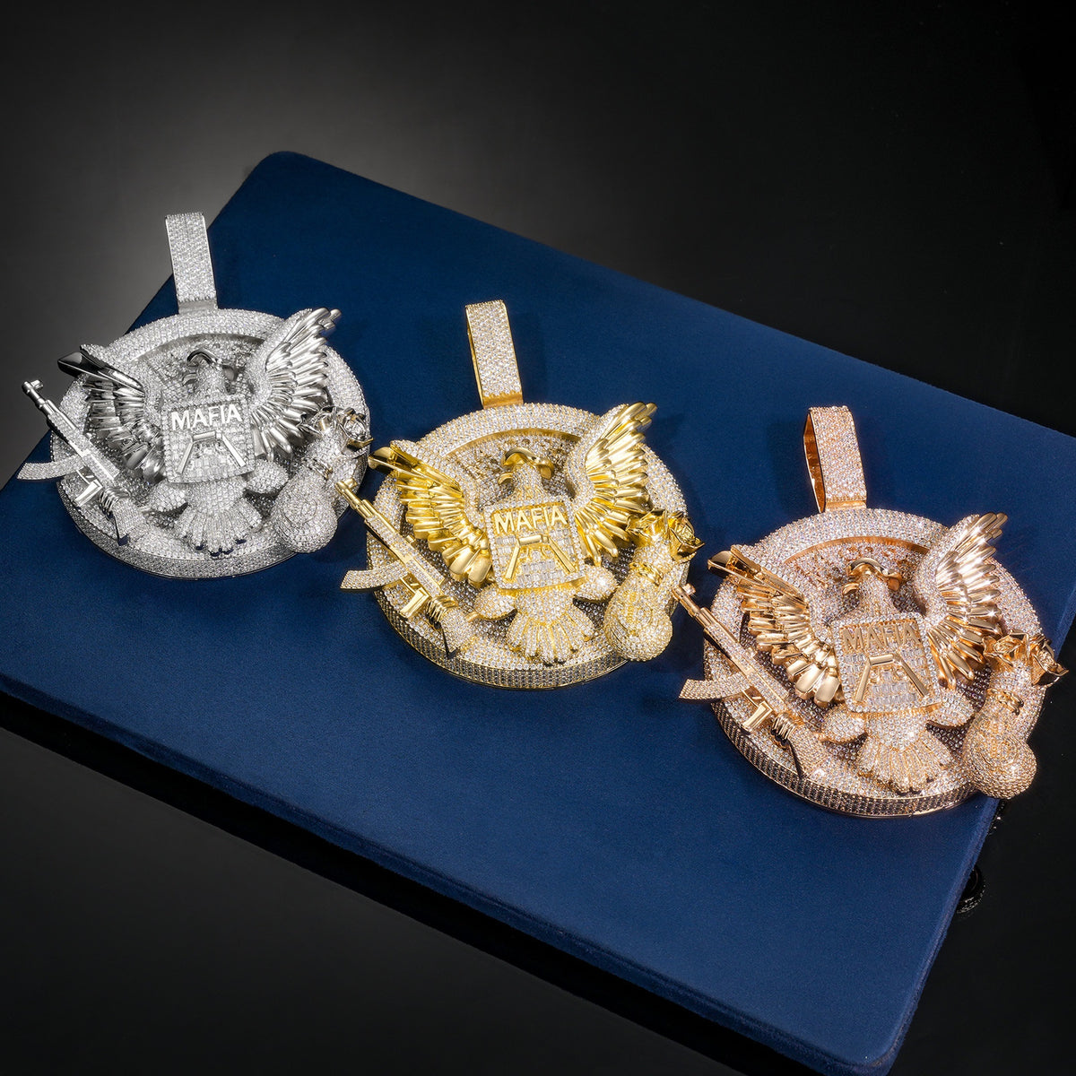 Silver, gold and rose gold-tone eagle medallion pendants on blue
