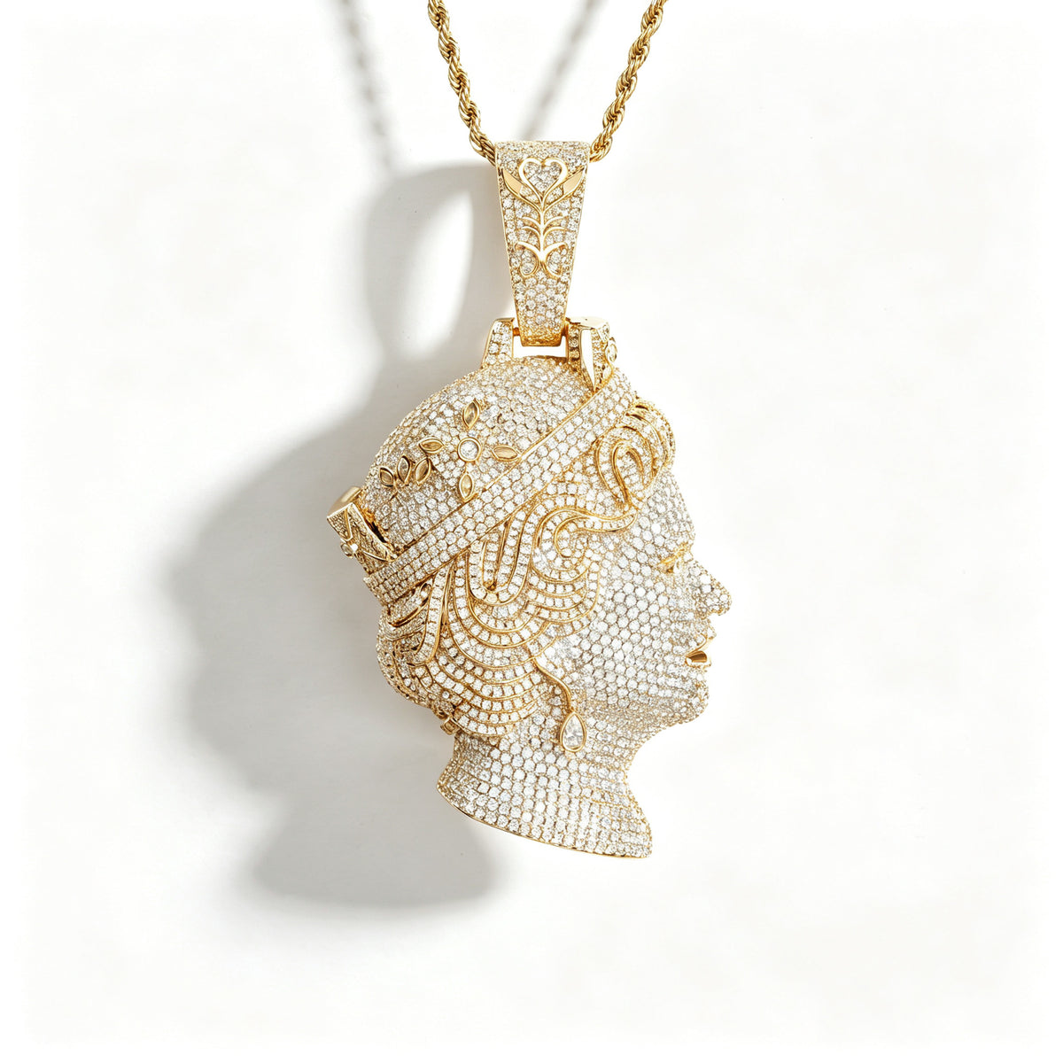 Gold-tone queen portrait pendant with a pavé face and tiara on white