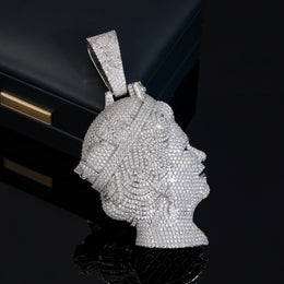 Silver-tone queen portrait pendant showing its stone-covered side on a black reflective surface