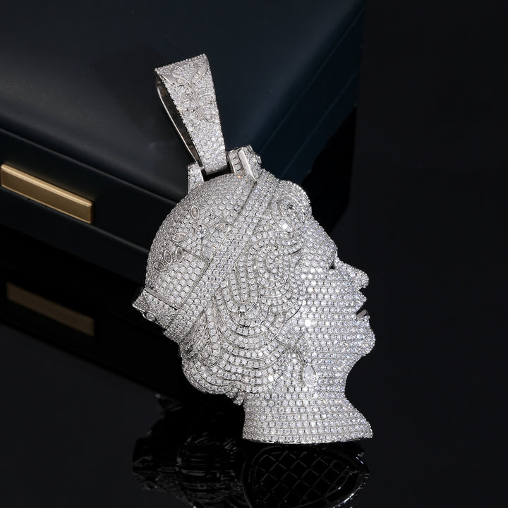 Silver-tone queen portrait pendant showing its stone-covered side on a black reflective surface
